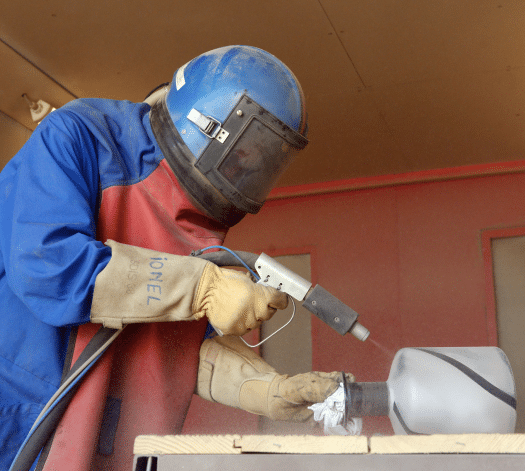 homme en combinaison peignant industriellement